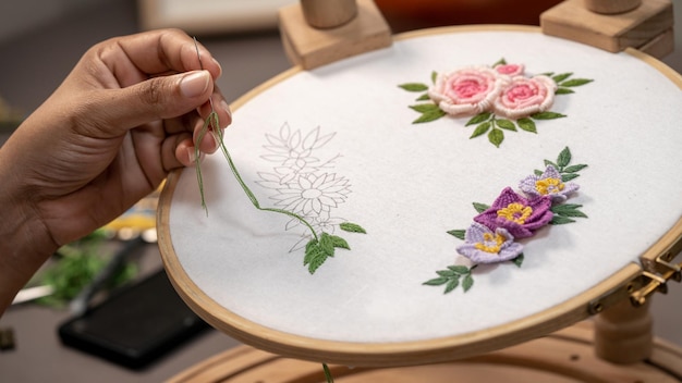 Osoba haftująca kwiaty w tamborku
